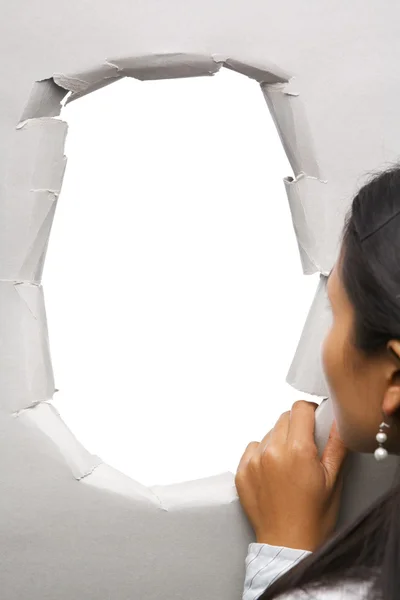 Mulher espreitando através de buraco na parede — Fotografia de Stock