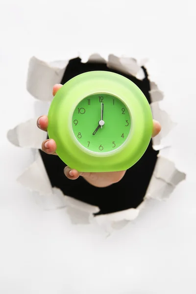 Mano svolta parete che tiene orologio verde — Foto Stock