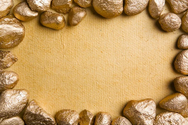 Бумага в обрамлении золотых самородков — стоковое фото