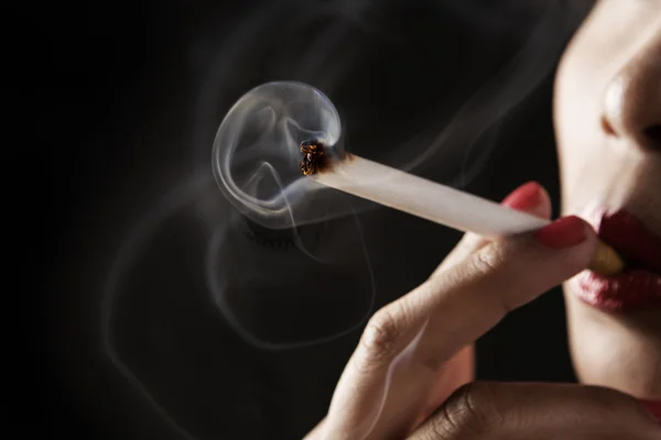 Женщина курит с дымом в форме скелета — стоковое фото