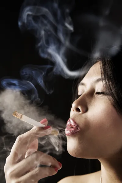 Женщина вдыхает дым от сигареты — стоковое фото