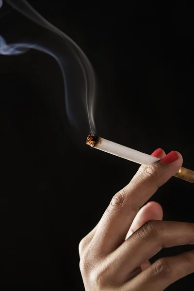 Doigts féminins tenant cigarette brûlante — Photo