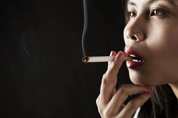 Femme fumant sur la zone sombre — Photo