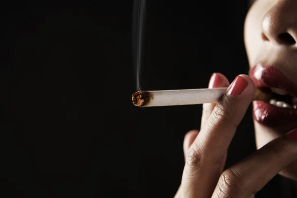 Žena kouření na tmavé oblasti — Stock fotografie