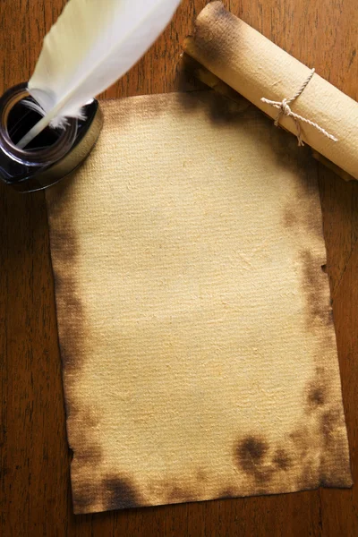 Papel viejo, pluma de pluma y pergamino sobre papel de madera — Foto de Stock