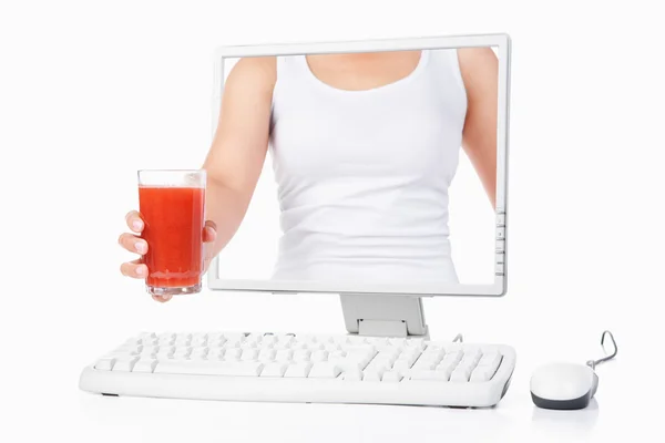 Frau hält Erdbeersaft in der Hand, der aus dem Computer kommt lizenzfreie Stockbilder