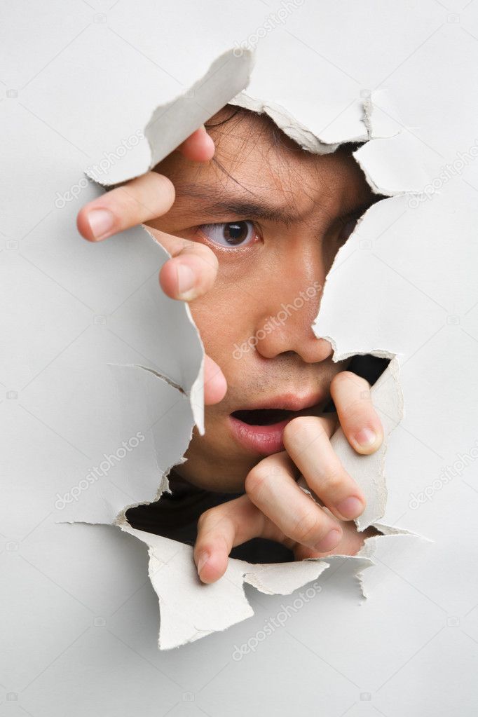 Man looks displeasure from cracked wall