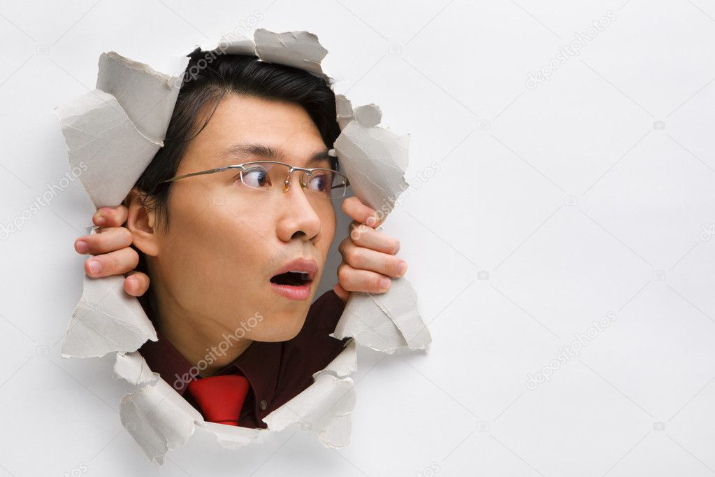 Man from hole in wall surprisingly looking away to his left side