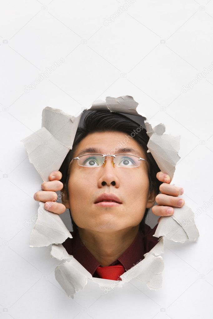 Man looking up from hole in wall