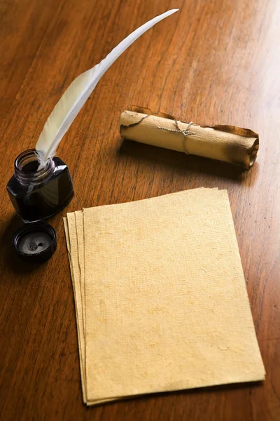 Papel viejo, pluma de pluma y pergamino sobre mesa de madera —  Fotos de Stock