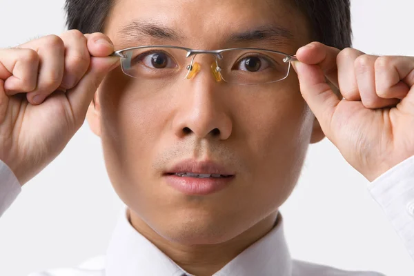 Asian businessman holding glasses to camera — Stock Photo, Image