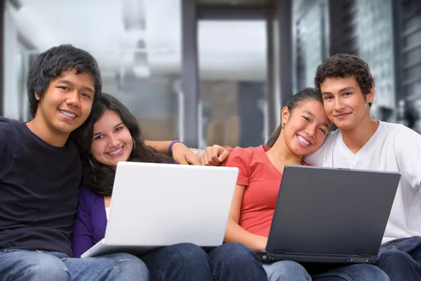 Две пары подростков с ноутбуками дома — стоковое фото