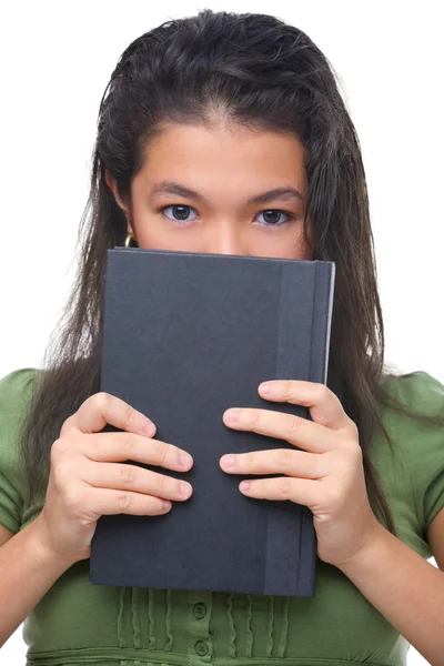 Mujer adolescente escondiendo hal su cara detrás de libro — Foto de Stock