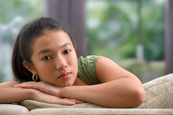 Female teenager on sofa at home — Stock Photo, Image