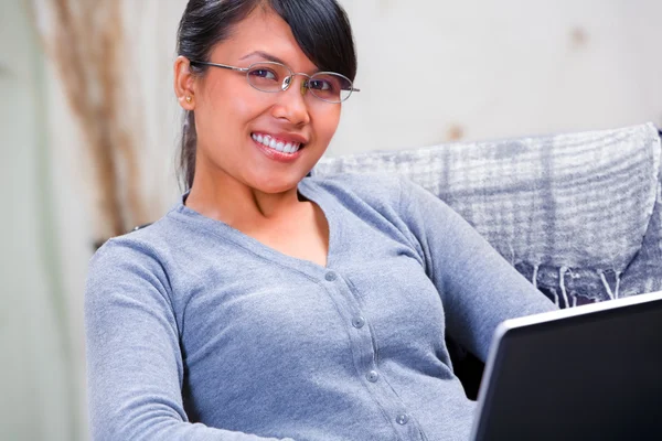 Mladá usměvavá žena s laptopem doma — Stock fotografie