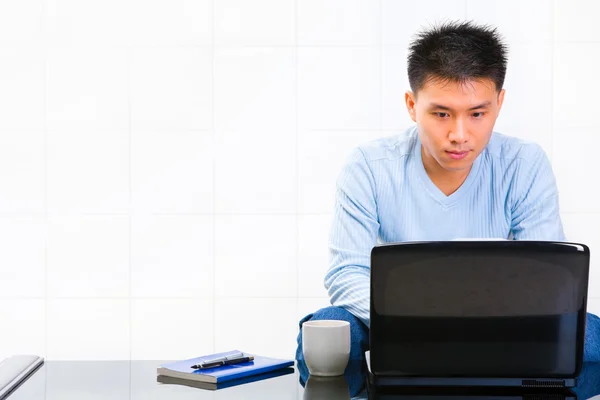 Hombre joven usando el ordenador portátil — Foto de Stock
