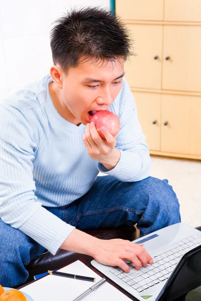 Apfel essen während der Arbeit zu Hause — Stockfoto
