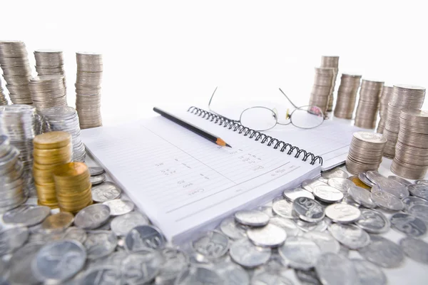 Accounting ledger between piles of coins — Stock Photo, Image
