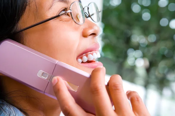 Zoomed face of a young woman using cell phone — Stock Photo, Image