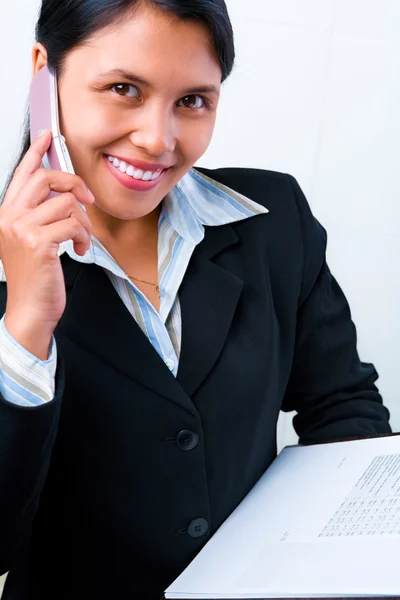 Businesswoman listening to her cell phone while holding document — Stock Photo, Image