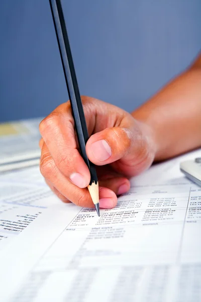 Hand working on financial report — Stock Photo, Image
