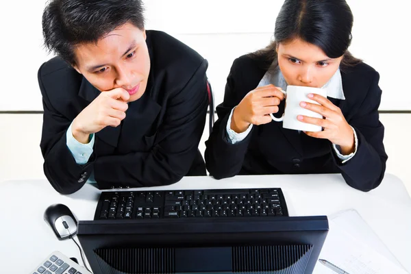 Junge asiatische Geschäftsleute im Amt untersuchen Monitor — Stockfoto