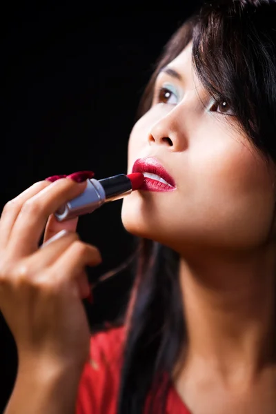 Junge Frau benutzt Lippenstift — Stockfoto