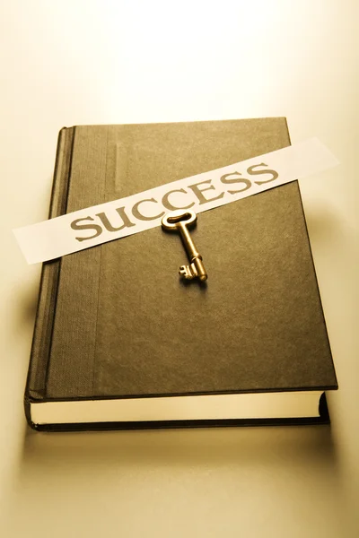 Book with golden key and success label (warm) — Stock Photo, Image