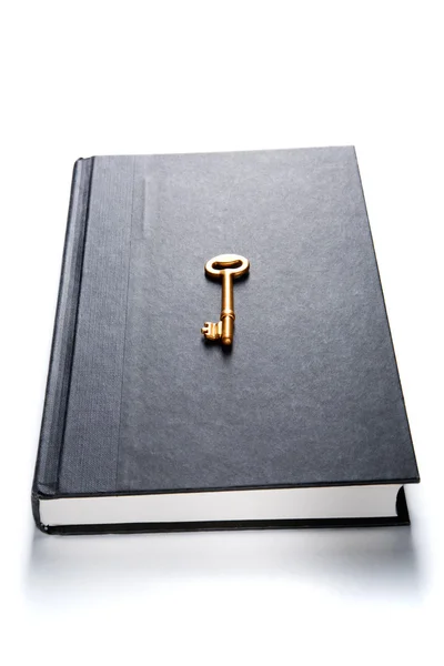 Golden key on book — Stock Photo, Image