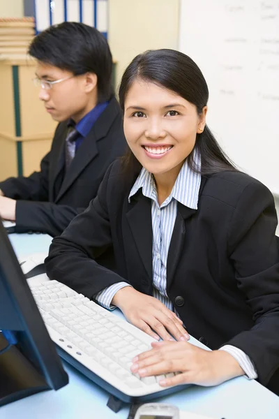 Kobieta pracownika jest uśmiechający się w biurze — Zdjęcie stockowe
