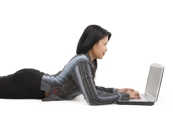 Usando um laptop enquanto se deita — Fotografia de Stock