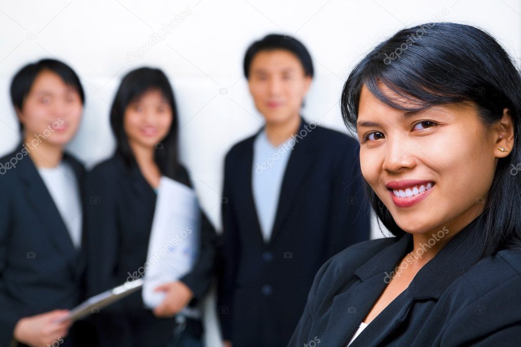 Young Asian Businesswoman smiling to camera with other on