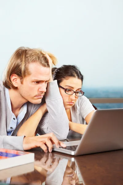 Depresssed couple in front of laptop — Stok fotoğraf