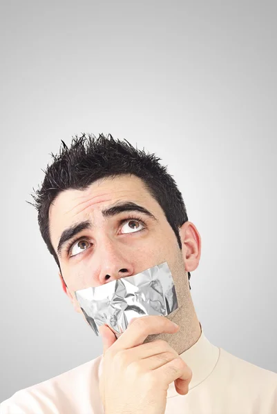 Curioso giovane uomo con nastro adesivo grigio sulla bocca — Foto Stock