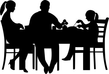 Family having their dinner at the table silhouette