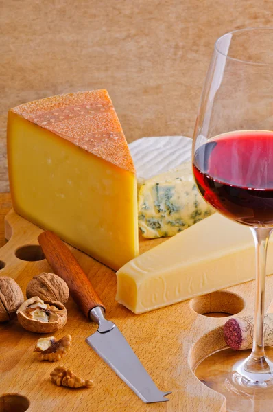 Rött vinglas och ost tallrik — Stockfoto