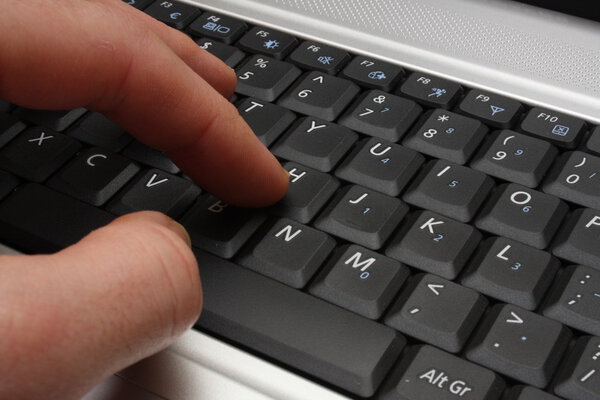 Hand pressing laptop keys
