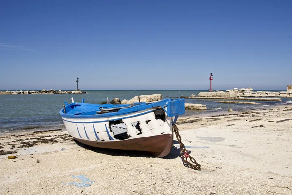 Small fishing blue burnt boat on the seashore — Stock Photo, Image