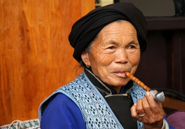 渓-雲南省、中国。年頃 2011 年 10 月。正体不明の古い女性は彼女のパイプを吸う. — ストック写真