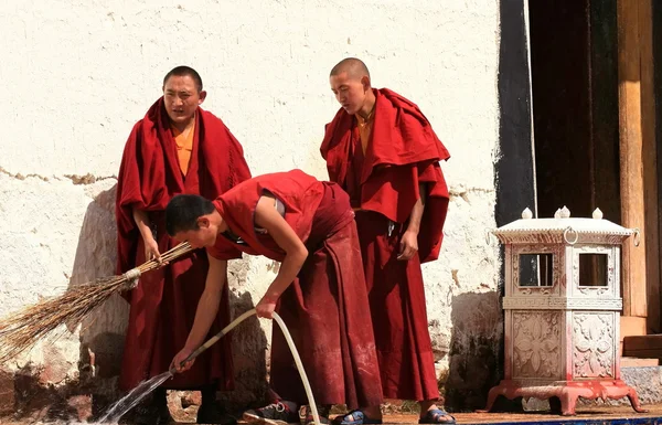 Zhongdian-yunnan, china. omstreeks oktober 2011. jonge monniken wassen de ingang. — Stockfoto