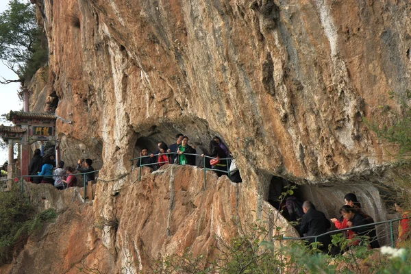 Sloučení skalním a turisté na cestě longmen dračí brána. — Stock fotografie
