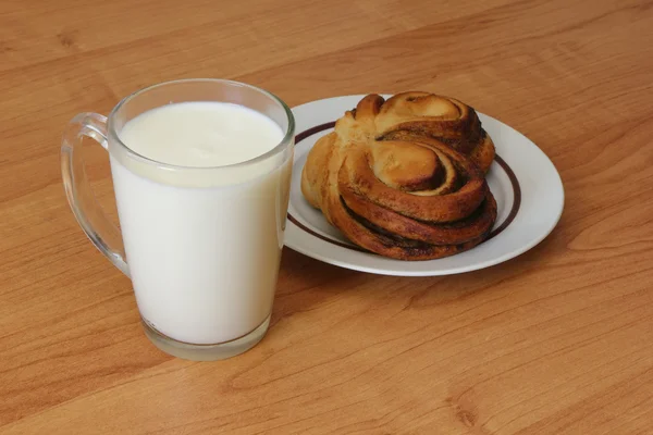A cup of milk and cinnamon bun — Stock Photo, Image