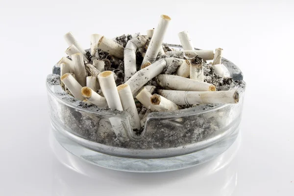 Cinzeiro e cigarros sobre fundo branco — Fotografia de Stock