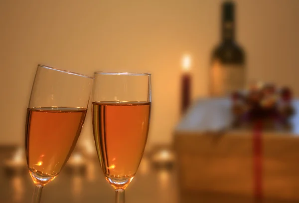 Two glasses of champagne with gift and candle — Stock Photo, Image