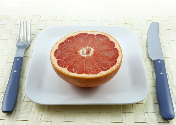 Diätkonzept Grapefruit auf dem Teller — Stockfoto