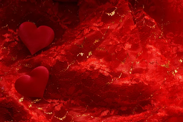 Kırmızı saten zemin üzerinde Hearts — Stok fotoğraf