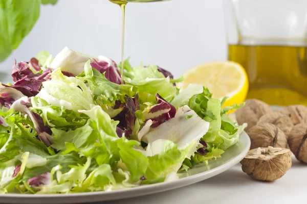 Vegetables salad and pouring oil — Stock Photo, Image