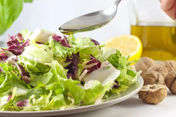 Vegetables salad and pouring oil — Stock Photo, Image