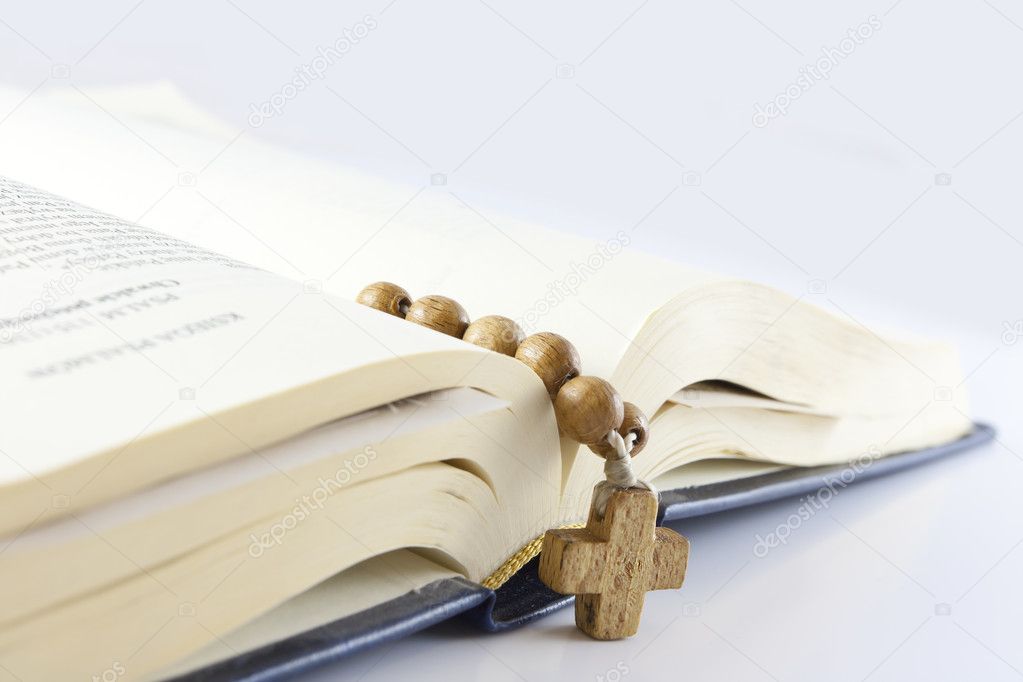 Open Bible with cross over white background