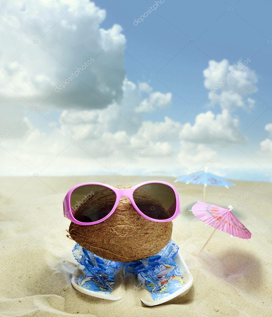 Coconut at beach with glasses and sandals fun concept